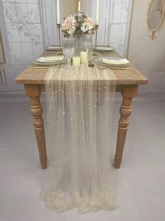 the table is set with candles, plates and napkins for two people to eat