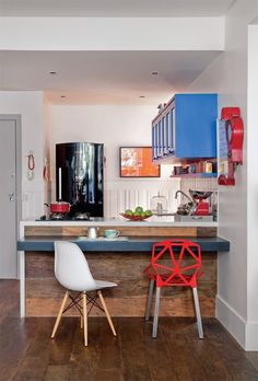 two chairs sitting in front of a kitchen island with blue counter tops and wooden flooring