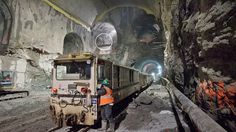 a man standing next to a train in a tunnel