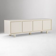 a white cabinet with four doors and three legs on the bottom, in front of a gray background