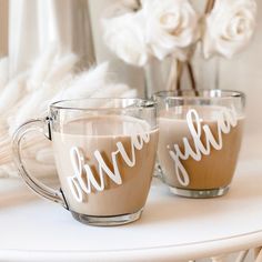 two coffee mugs sitting on top of a white table