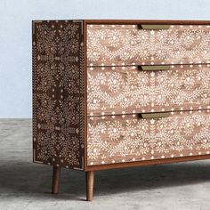 a brown and white dresser sitting on top of a cement floor