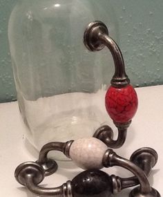 a glass bottle with a metal hook and some beads on it