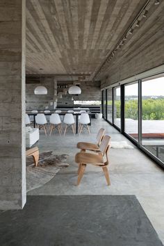 an open living room and dining area with large windows on the side of the house