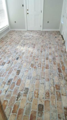 an empty room with brick flooring and white doors