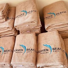 towels stacked on top of each other with the logo for heaven beach resort and spa