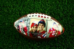 an image of a football on the grass with two people's faces painted on it