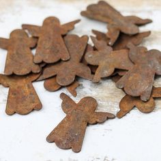 old rusty metal angel cutouts are scattered on the floor in front of a white background