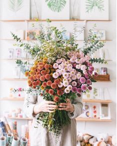 a woman holding a bunch of flowers in her hands