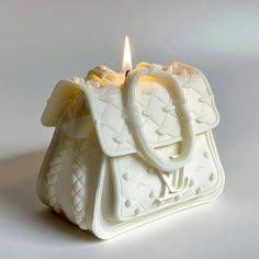 a small white purse with a lit candle in it