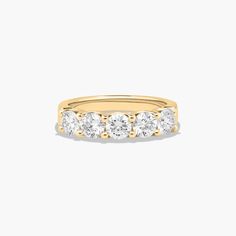 a yellow gold ring with five diamonds