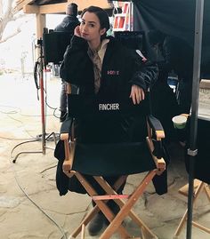 a woman sitting in a chair with her hand on her face