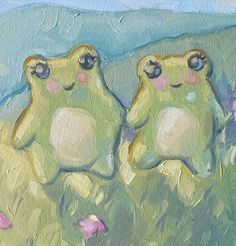 two green frogs are sitting in the grass