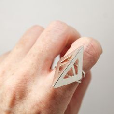 Featuring an abstract design inspired by a bird’s beak, this sterling silver ring is created from hand sawn sterling silver sheet, filed and refined into shape, with striations from the file left for a subtle stylistic texture. Overall design set on a twin hammered ring base. Polished to a high shine. Modern Geometric Sterling Silver Rings, Modern Sterling Silver Rings With Geometric Shape, Modern Sterling Silver Rings With Geometric Design, Geometric Sterling Silver Ring, Geometric Silver Ring As Gift, Silver Geometric Sterling Silver Ring, Silver Geometric Rings As Gifts, Silver Geometric Ring As Gift, Silver Geometric Ring Gift