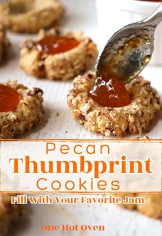 a spoon is being used to scoop out peanut butter cookies from a baking sheet with the words pecan thumpprint cookies written on it