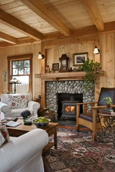 a living room filled with furniture and a fire place in the middle of a wooden wall