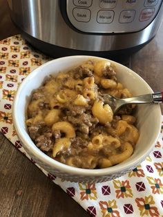 a bowl filled with macaroni and cheese next to an instant pot