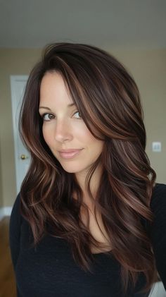 This hairstyle features luxuriously flowing long waves imbued with rich, warm highlights that beautifully frame the face. To achieve this look, start by applying a volumizing mousse to damp hair before blow-drying with a round brush for added lift. Use a curling wand on sections of hair to create soft, loose waves, then gently tousle with your fingers for that effortless vibe. Finish with a light-hold hairspray to maintain movement without stiffness. Chocolate Brown Hair With Highlights, Warm Highlights, Volumizing Mousse, Using A Curling Wand, Chocolate Brown Hair, Brown Hair With Highlights, Wand Curls, Loose Waves, Blow Dry