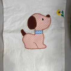 a white pillow with a brown dog embroidered on it