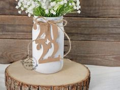 a mason jar filled with flowers on top of a wooden stump