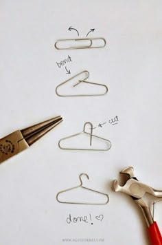 scissors and paper clips on top of a piece of paper