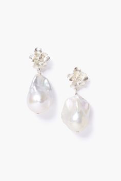 two pairs of pearl and crystal earrings on a white background, one with a flower in the middle