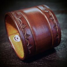 "This brown leather cuff is 2.25\" wide and uses Natural vegetable tanned leather and is hand dyed in a beautiful saddle brown! A classic stamped border and tooled center adorn the main cuff and another tooled section contains hand aged nickel snaps and a beautiful old school, aged copper rivet! I'll need your wrist size for this cuff! Please use the instructions in the pics above! - 2.25' wide - vegetable tanned leather - Old west style Thx! Freddie" Vintage Hand-tooled Leather Cuff Bracelet, Western Leather Cuff Bracelet As Gift, Classic Engraved Brown Leather Bracelet, Classic Brown Engraved Leather Bracelet, Western Hand Tooled Leather Bracelet, Western Style Hand Tooled Leather Bracelets, Vintage Hand Tooled Cuff Leather Bracelet, Vintage Hand Tooled Leather Cuff Bracelet, Handmade Leather Western Cuff Bracelet