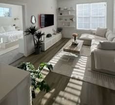 a living room filled with furniture and a flat screen tv on top of a wooden floor