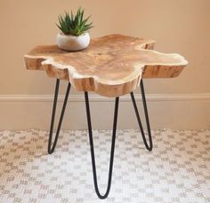 a small wooden table with hairpin legs and a plant on it's top