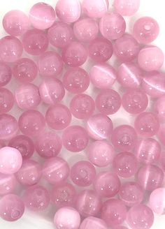 some pink beads are on a white surface