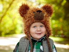 a little boy wearing a bear hat and jacket