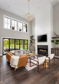 a large living room with white walls and wood flooring is pictured in this image