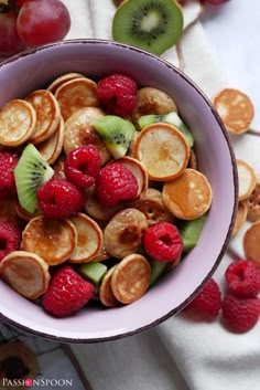 a bowl filled with fruit and sliced kiwis