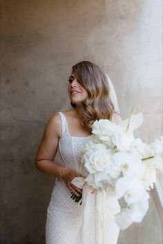 a woman in a wedding dress holding a bouquet