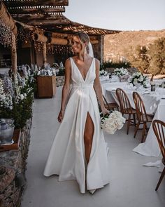 a woman in a white wedding dress is walking towards the camera