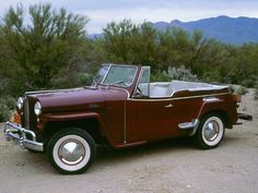 an old red truck parked in the desert