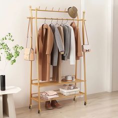 a coat rack with clothes hanging on it in a room next to a table and chair