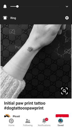 a person with a small tattoo on their wrist and the words initial paw print tattoo