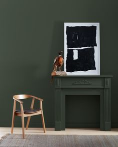 a green room with a chair, table and painting on the wall next to it