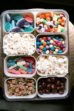 a container filled with lots of different types of candy and marshmallows in it