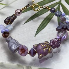 Czech Glass cat bracelet  Sweet cat bracelet made with Czech Glass in shades of purple.  Solid Brass cat charm closure with spring ring and extender chain.  Boxed in boutique packaging and ready for gift giving This purchase directly supports our cat rescue efforts 🐾 Boutique Packaging, Cat Bracelet, Glass Cat, Sweet Cat, Purple Cat, Whimsical Cats, Cat Charm, Crystal Beads Bracelet, Cat Jewelry