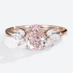 a pink diamond ring with three pear shaped diamonds