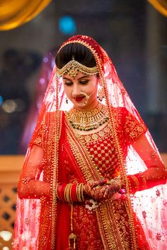 a woman in red and gold wedding outfit