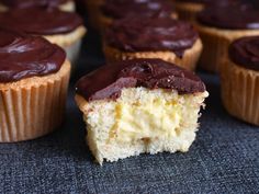 cupcakes with chocolate frosting sitting on top of a blue cloth covered table