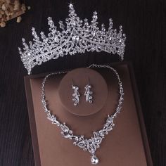 a tiara and earrings are on display in a box next to a flower arrangement