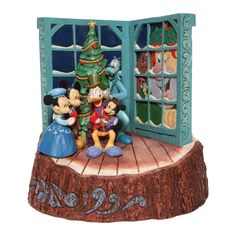 the figurine depicts mickey and minnie in front of a christmas tree