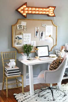 a white desk topped with a laptop computer under a lighted arrow above it's head