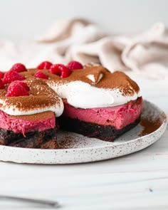 two desserts with raspberries and whipped cream are on a white platter