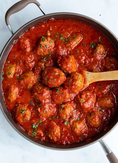 meatballs and sauce in a pan with a wooden spoon on the side, ready to be eaten