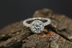 a diamond ring sitting on top of a piece of wood